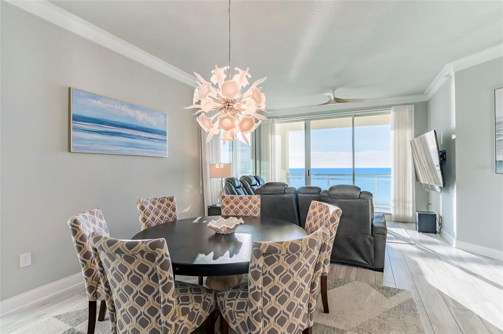 A dining area with a round table and patterned chairs overlooks a balcony and ocean — 1170 GULF BOULEVARD UNIT 2203, CLEARWATER BEACH, FL