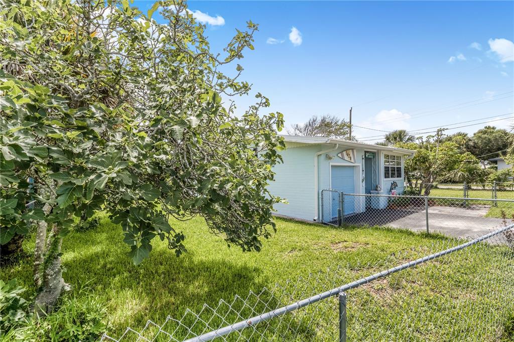 A light blue house with a garage and a chain-link fence in the yard — 1420 N GRANDVIEW AVENUE, DAYTONA BEACH, FL