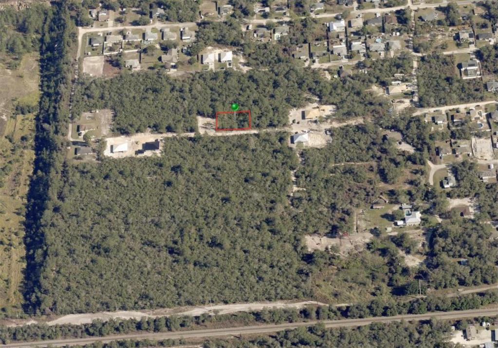 An aerial view shows a rectangular plot of land outlined in red amidst wooded terrain — WALDOR AVENUE, ORANGE CITY, FL