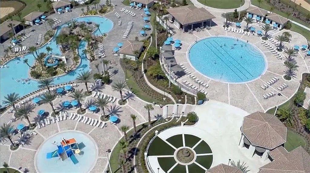 An aerial view shows a community pool complex with a lazy river and splash pad — 811 OCEAN COURSE AVENUE UNIT 811, DAVENPORT, FL