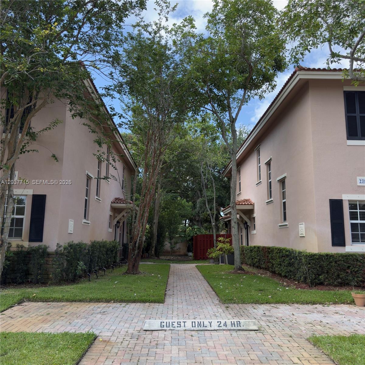 A brick walkway leads between two light-colored, two-story residential buildings with green lawns — 280 Las Brisas Cir # 280, Sunrise FL 33326, SUNRISE, FL