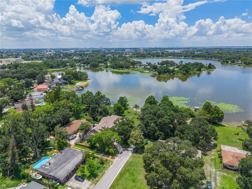 An aerial view shows houses nestled among trees along the shore of a large lake — 430 BYWATER DRIVE, ORLANDO, FL