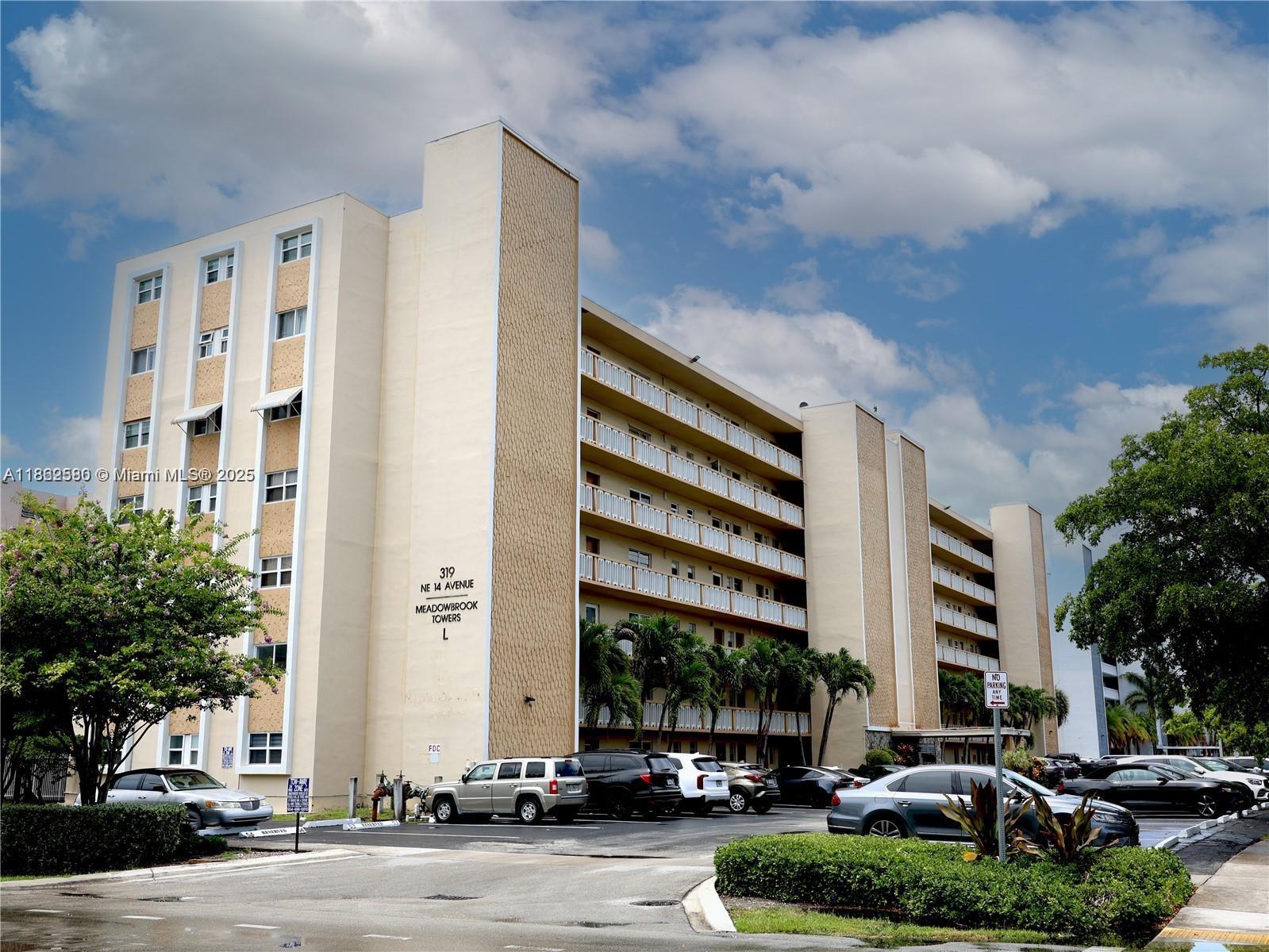 A multi-story apartment building with a parking lot and palm trees in front — 319 NE 14th Ave # 505, Hallandale Beach FL 33009, HALLANDALE BEACH, FL