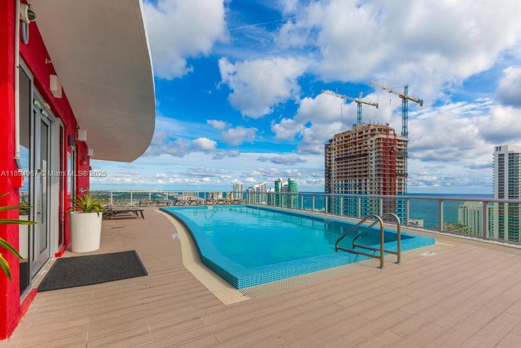An outdoor rooftop swimming pool overlooks the ocean and nearby high-rise buildings — 2602 E Hallandale Beach Blvd # R1507, Hallandale Beach FL 33009, HALLANDALE BEACH, FL