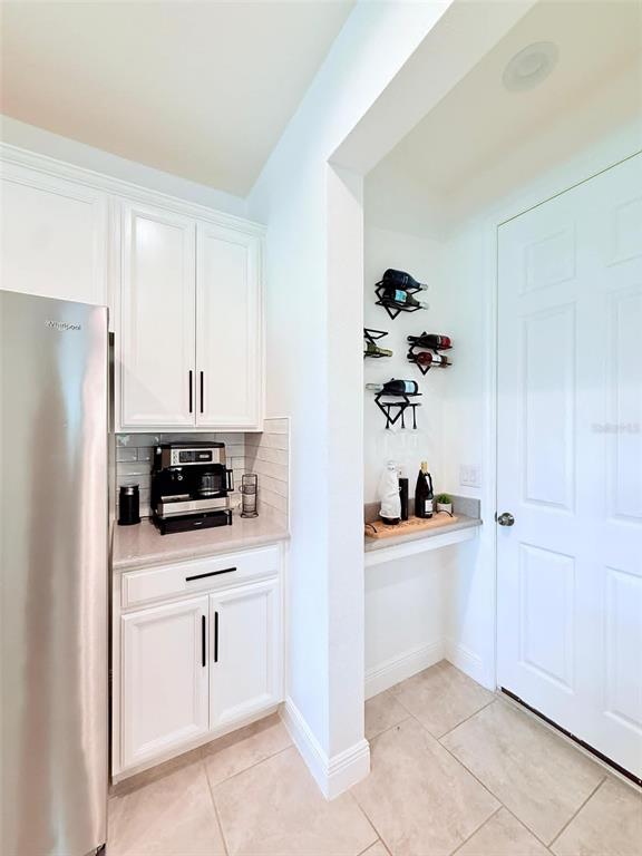 A kitchen area features white cabinets, a coffee station, and a small built-in wine rack — 2993 NOTTEL DRIVE, ST CLOUD, FL