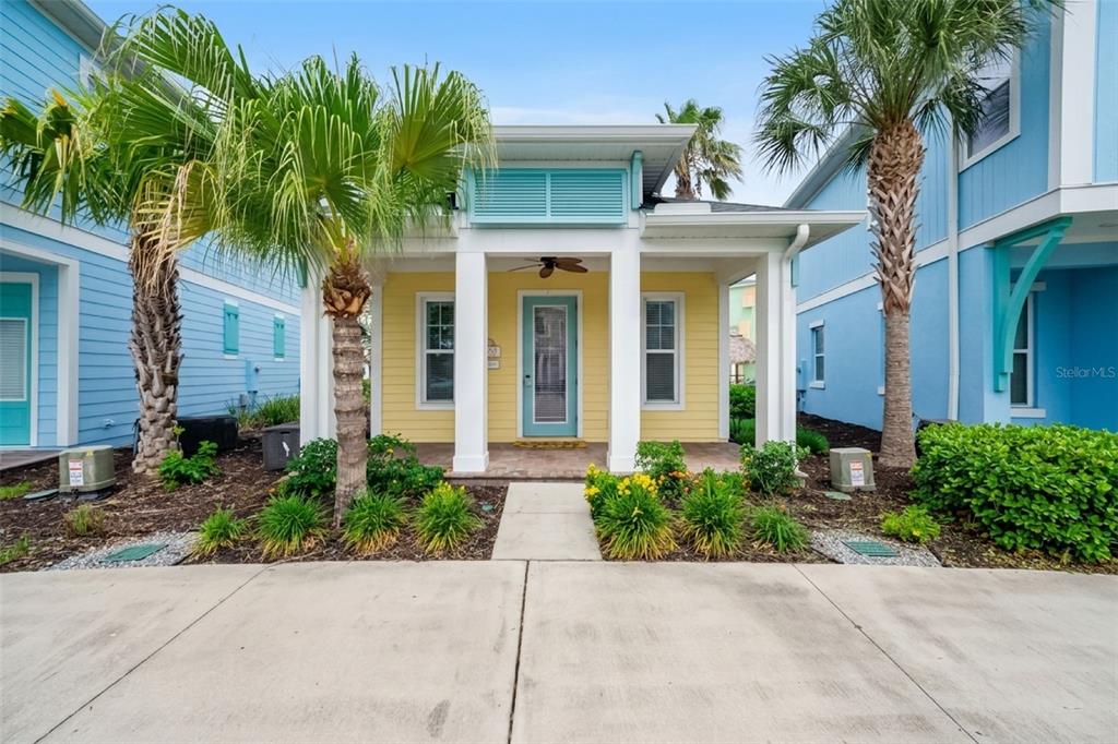 An open-concept kitchen and living area features white cabinetry, a dining table, and yellow walls — 3054 PIRATE WAY, KISSIMMEE, FL