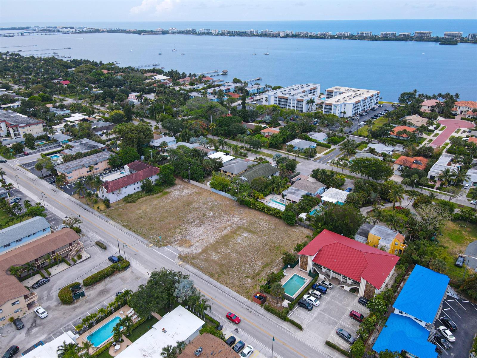 An aerial view shows a vacant lot situated between residential buildings and a coastal waterway — 1600 S Federal Highway, FL 33460, FL