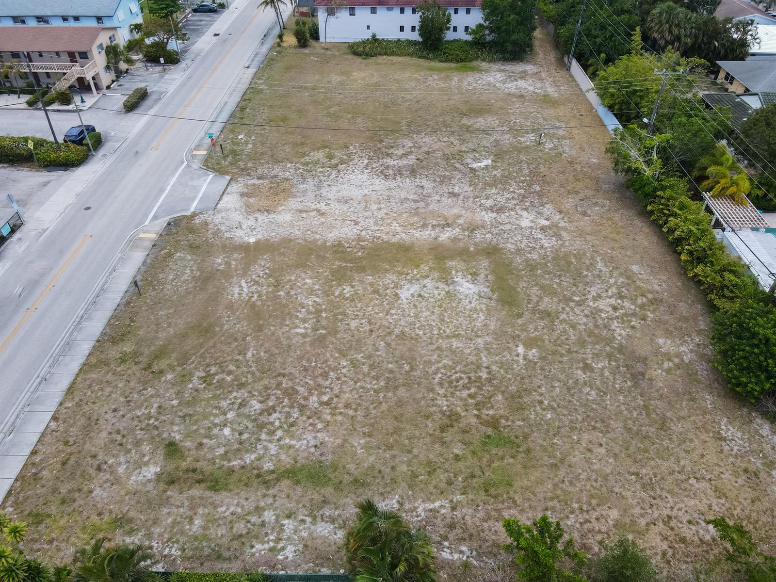 An aerial view shows a vacant, rectangular grassy lot adjacent to a paved road — 1600 S Federal Highway, FL 33460, FL