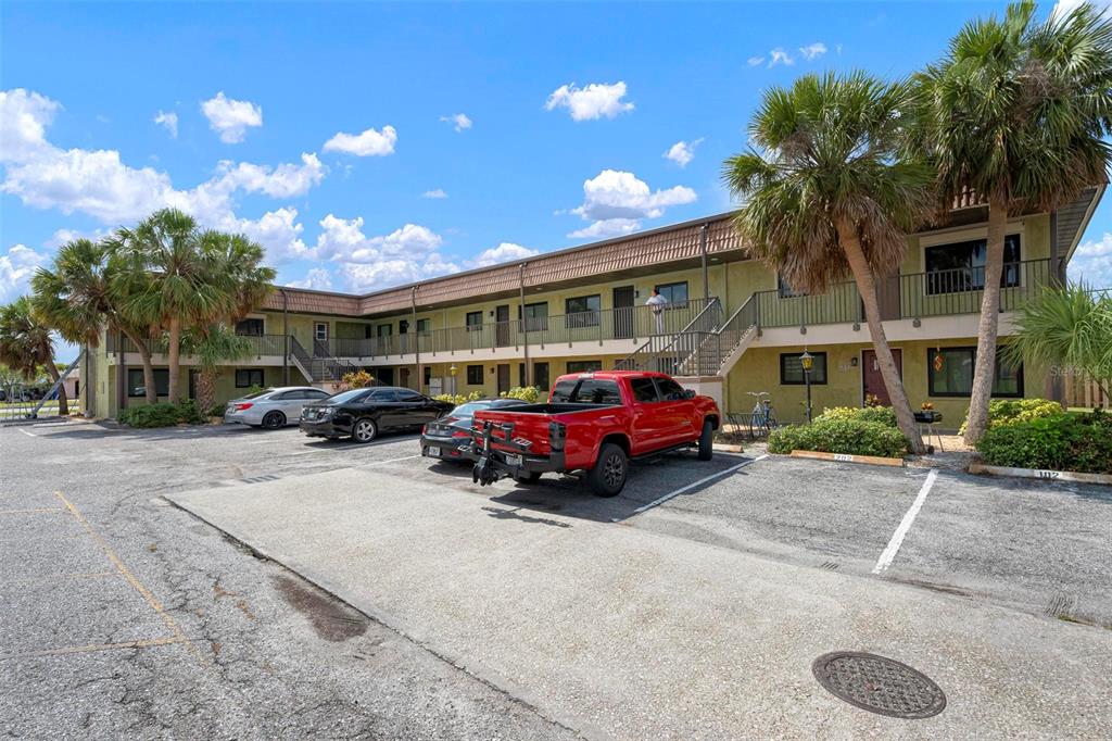 A two-story apartment building with a parking lot and palm trees in front — 1258 BARBARA DRIVE UNIT 107, VENICE, FL