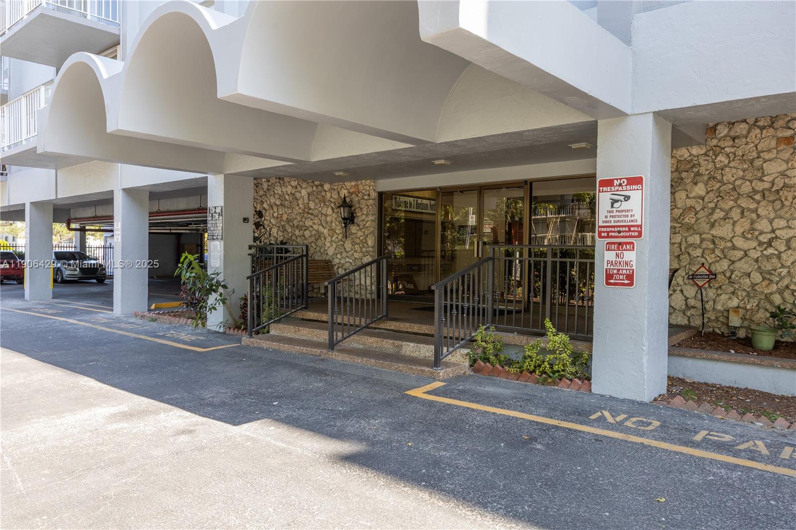 The exterior entrance of a building features a stone facade, glass doors, and stairs — 1470 NE 125th Ter, North Miami FL 33161, NORTH MIAMI, FL
