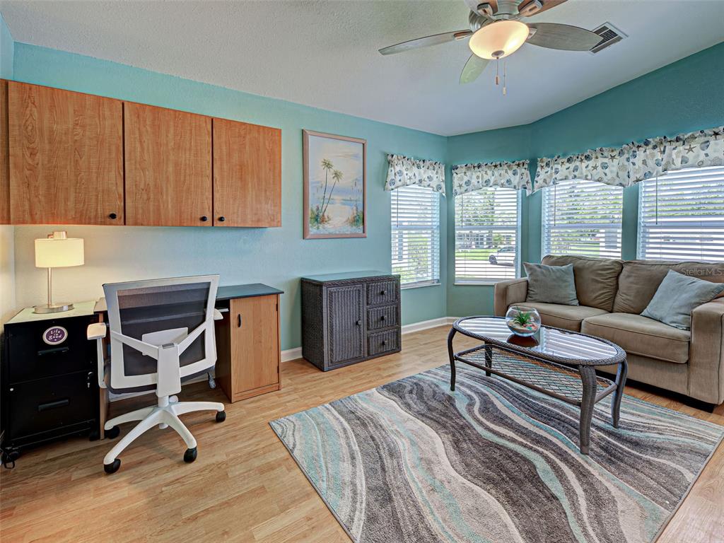 A light yellow manufactured home features a stone-patterned driveway and a covered front porch — 6562 HIKINA DRIVE, NORTH PORT, FL