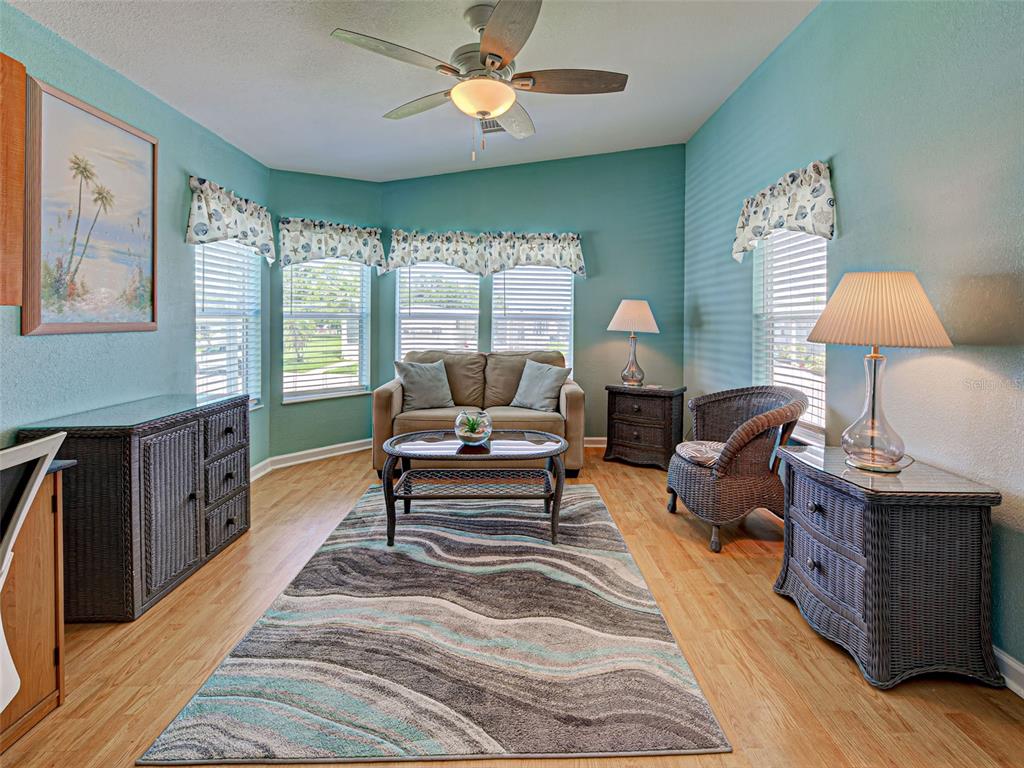 A home office with a desk, sofa, area rug, and light blue walls — 6562 HIKINA DRIVE, NORTH PORT, FL