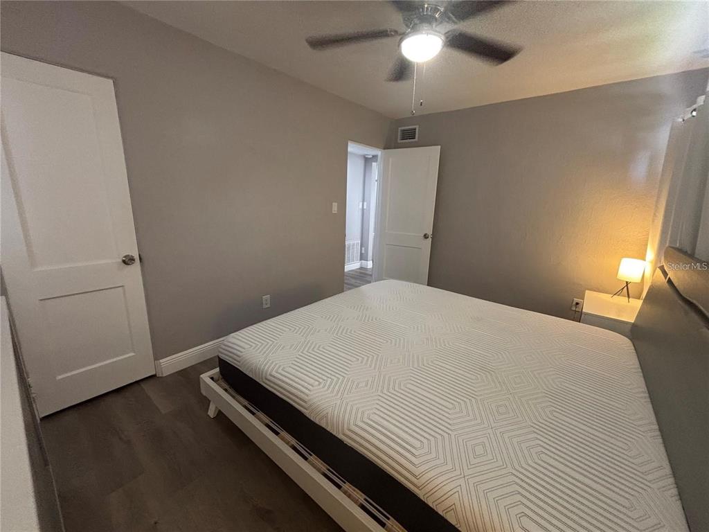 A bedroom features gray walls, wood-look flooring, a ceiling fan, and a bed with a patterned mattress — 6035 SAGE DRIVE, ORLANDO, FL