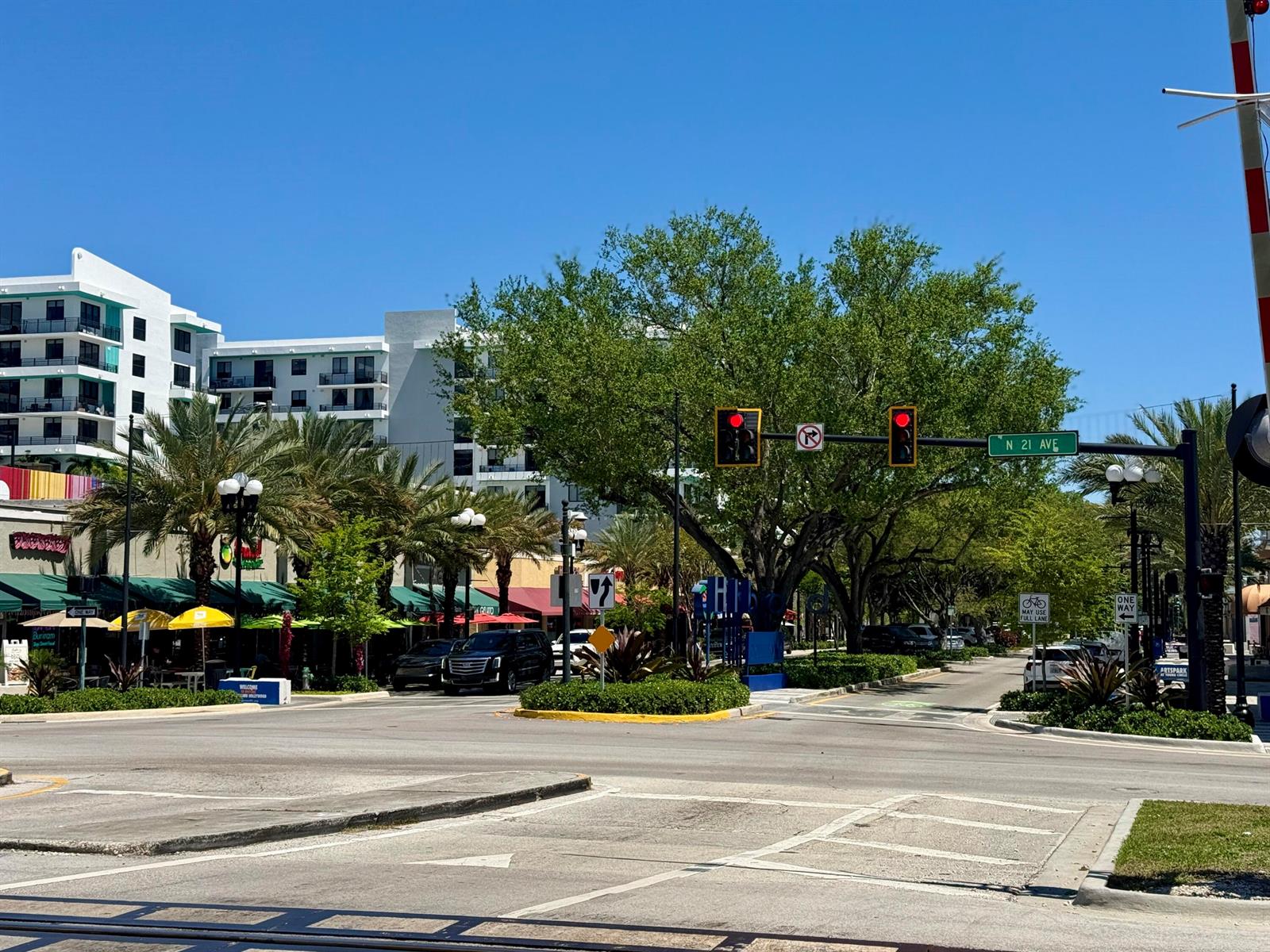 A street intersection with traffic lights, palm trees, and modern apartment buildings under a clear sky — 140 S Dixie Highway # 1002, Hollywood FL 33020, HOLLYWOOD, FL
