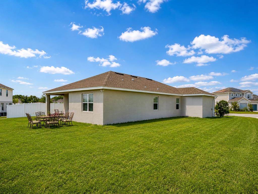 The exterior of a beige house with a covered patio and a large grassy yard — 236 HILLCREST DRIVE, DUNDEE, FL