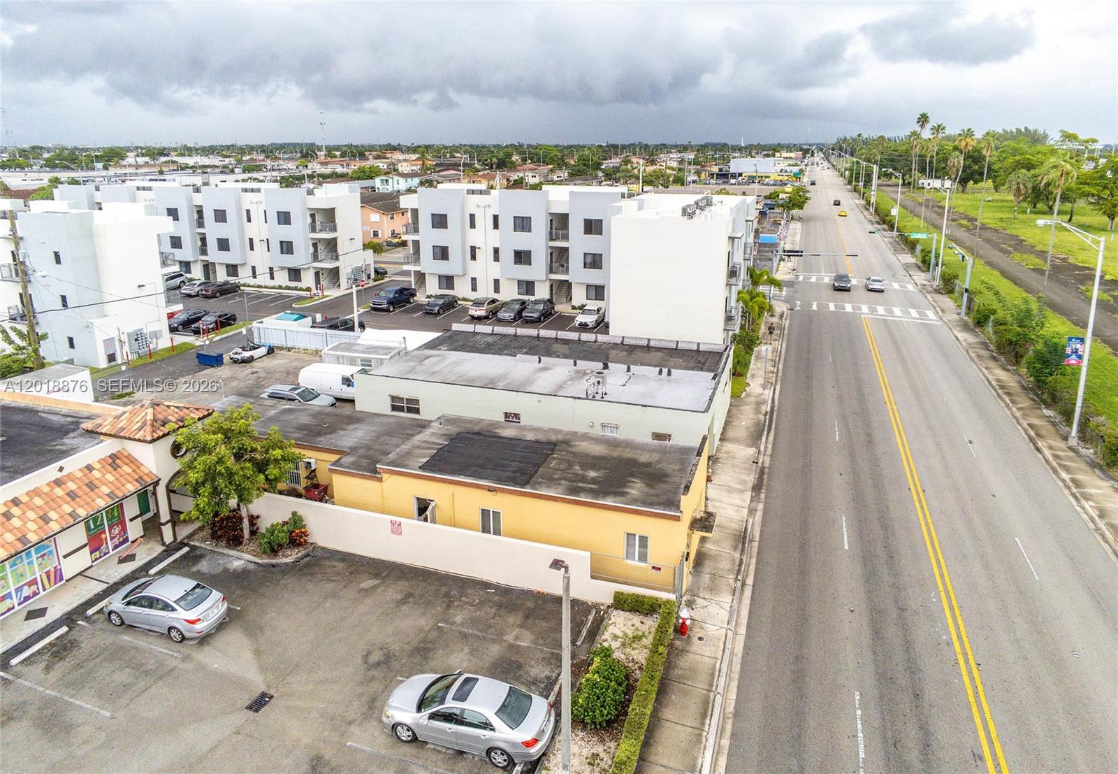 An aerial view shows a commercial building, a parking lot, and a multi-story apartment complex — 2250 Palm Ave, Hialeah FL 33010, HIALEAH, FL