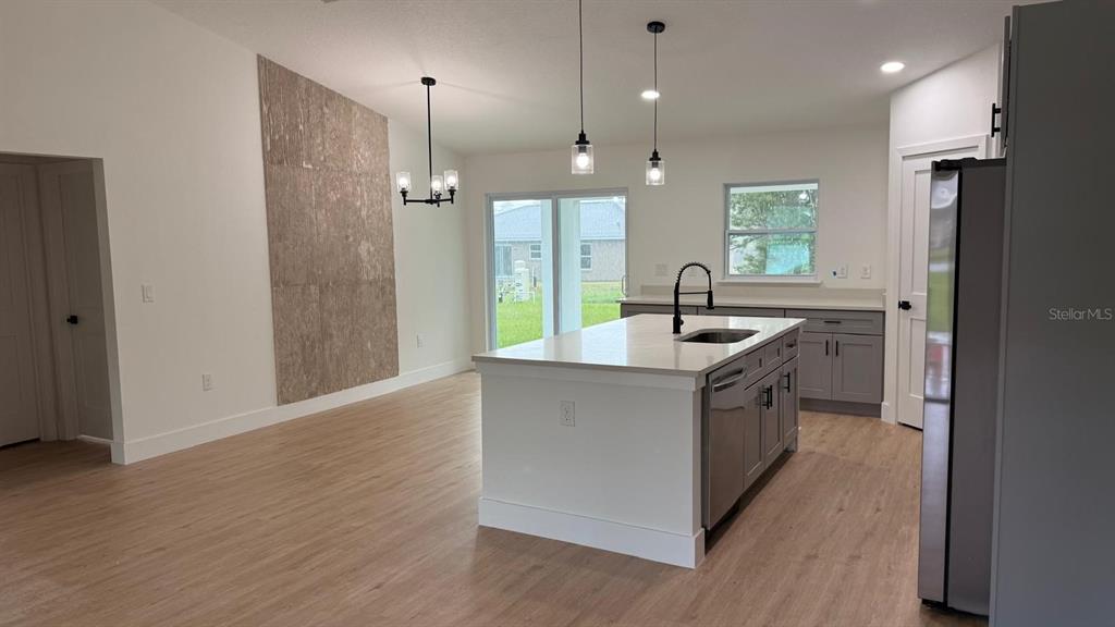 A single-story house with a white stucco exterior, dark trim, and a two-car garage — 17 MALAUKA RUN DRIVE, OCKLAWAHA, FL