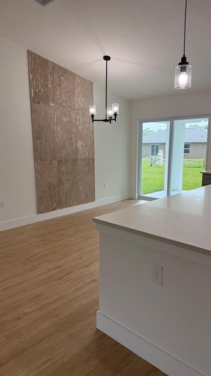A dining room features a wooden table, six chairs, a textured wall accent, and pendant lighting — 17 MALAUKA RUN DRIVE, OCKLAWAHA, FL