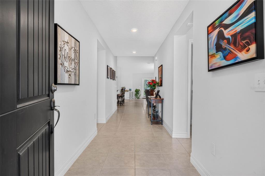 A tiled entryway leads down a long hallway toward an open living area — 13737 RUSHING CREEK RUN, ORLANDO, FL