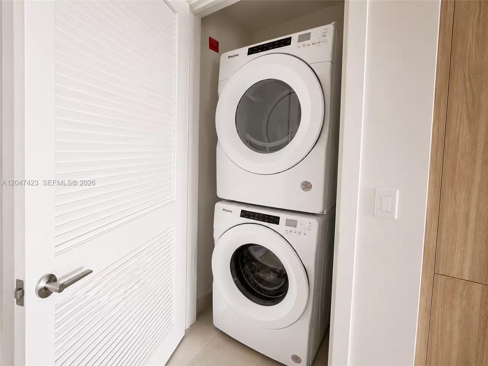 A stacked Whirlpool washer and dryer unit is located inside a small closet — 159 NE 6th St # 3212, Miami FL 33132, MIAMI, FL