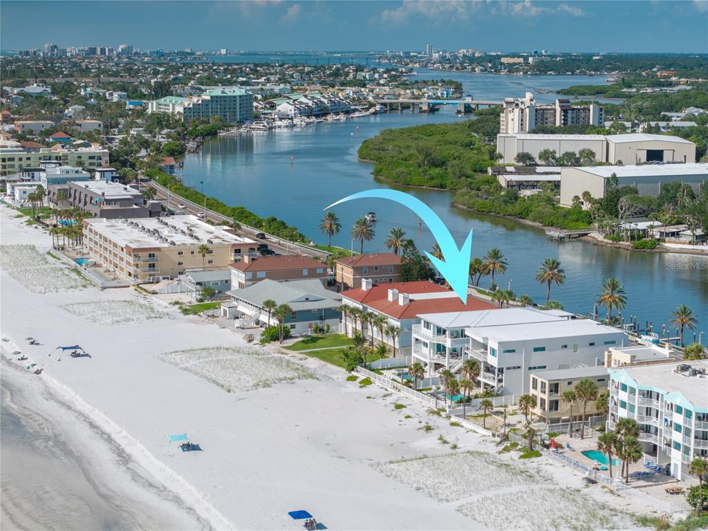 An aerial view shows a multi-story beachfront building with a red roof and white balconies — 34 GULF BOULEVARD, INDIAN ROCKS BEACH, FL