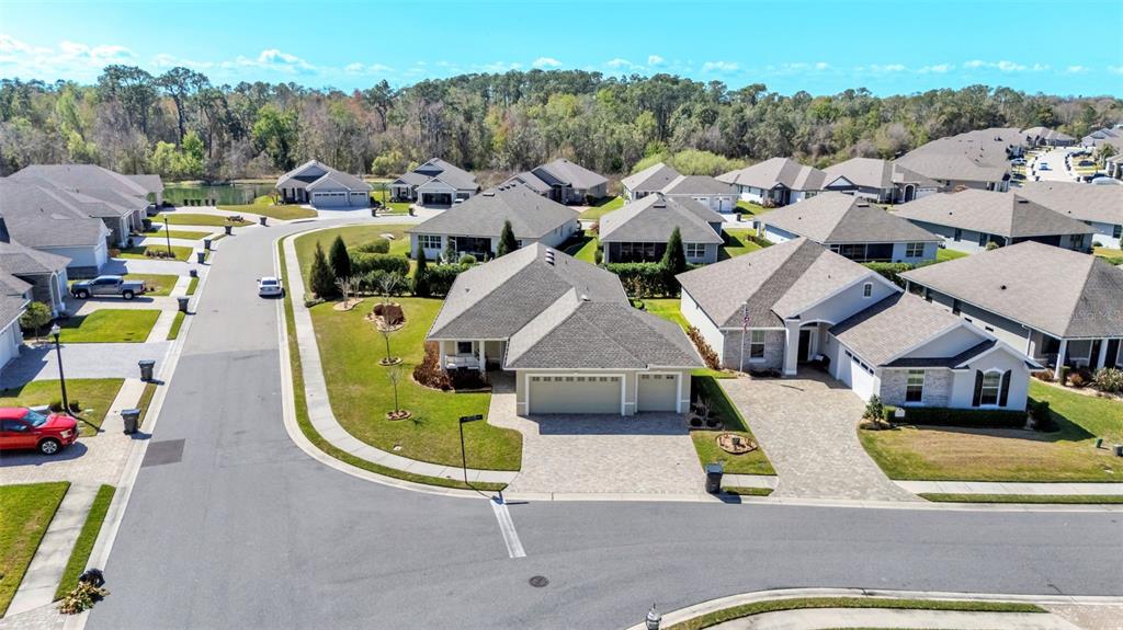 An aerial view shows a suburban neighborhood with single-family homes, paved driveways, and green lawns — 7766 LAKE JAMES BOULEVARD, LAKELAND, FL