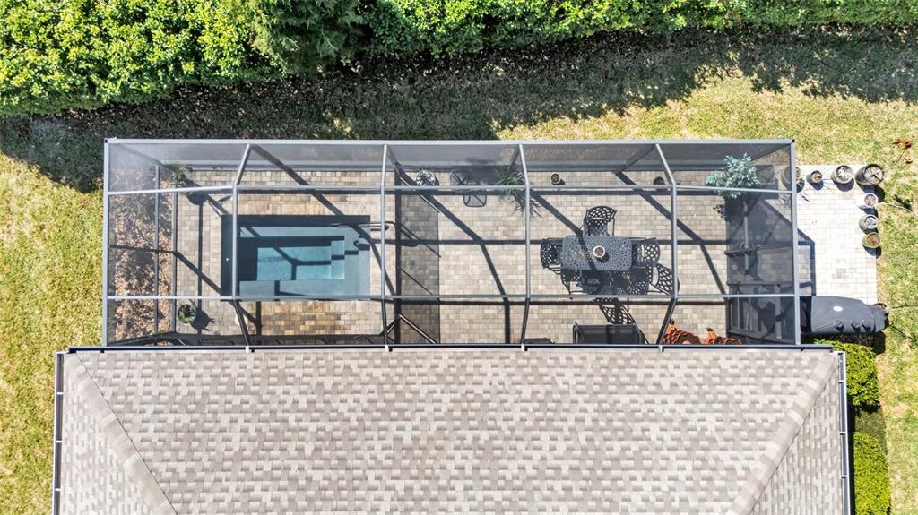 An aerial view shows a screened-in patio with a small pool and outdoor dining set — 7766 LAKE JAMES BOULEVARD, LAKELAND, FL