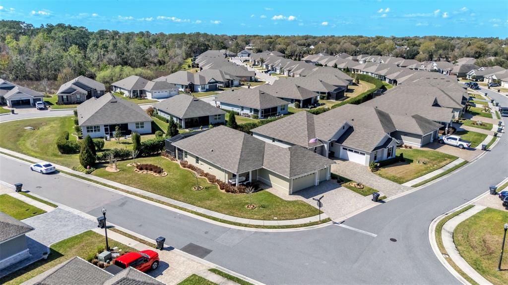 An aerial view shows a suburban neighborhood with multiple single-family homes and paved streets — 7766 LAKE JAMES BOULEVARD, LAKELAND, FL