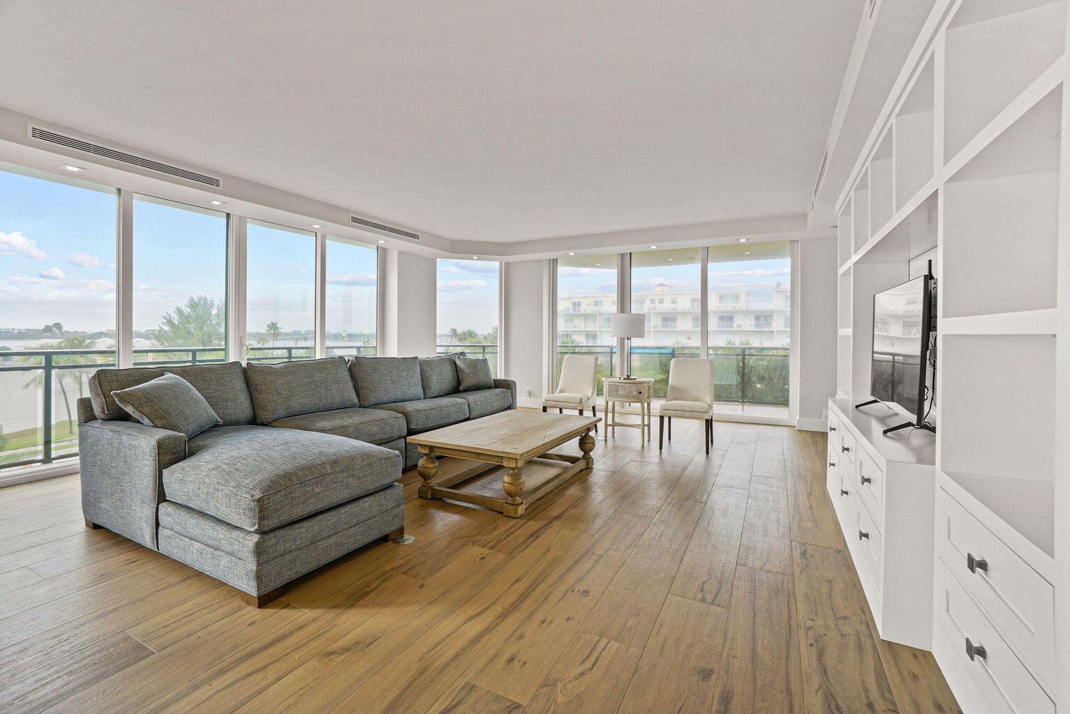 A living room with a gray sectional sofa, wooden coffee table, and floor-to-ceiling windows — 3100 S Ocean Boulevard # 306n, Palm Beach FL 33480, PALM BEACH, FL