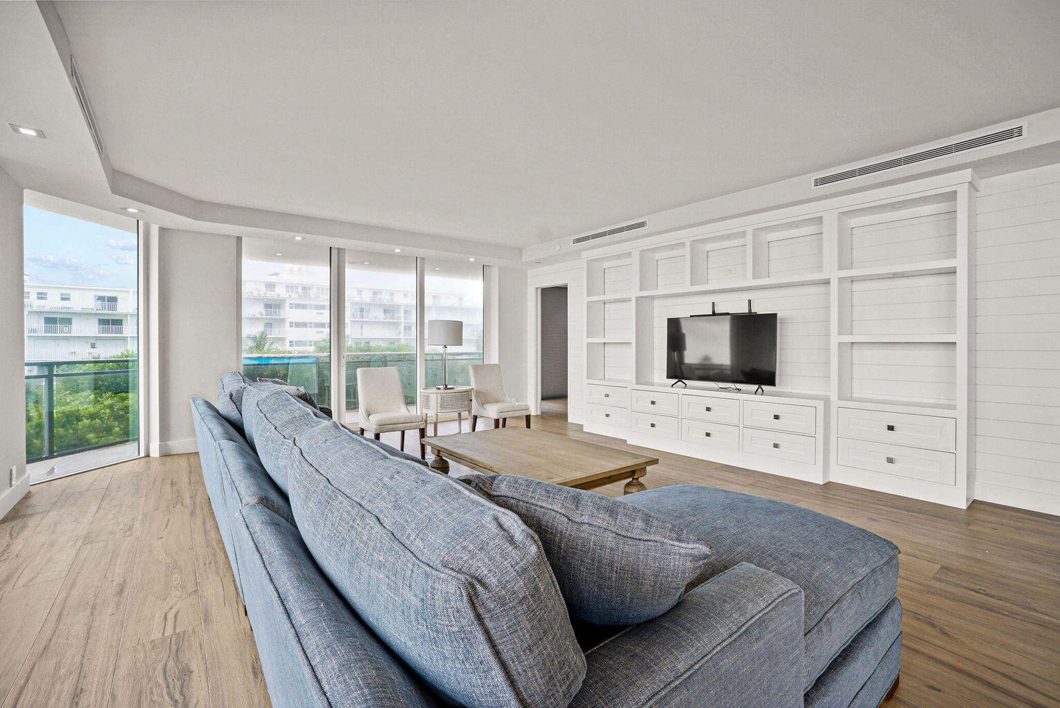 A living room features a blue sectional sofa, a wooden coffee table, and built-in shelving — 3100 S Ocean Boulevard # 306n, Palm Beach FL 33480, PALM BEACH, FL