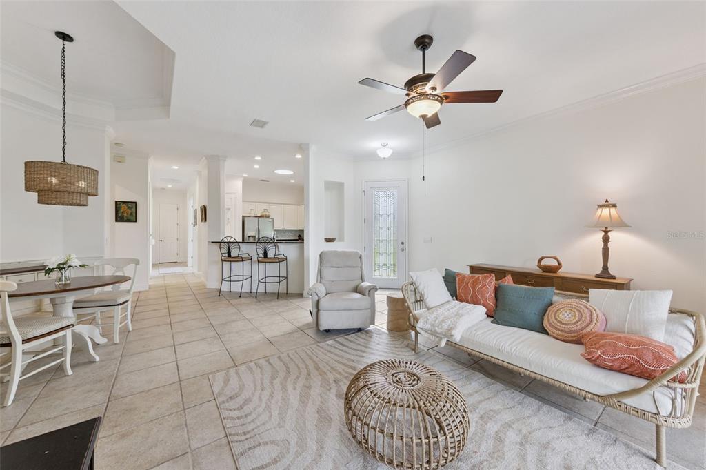 A living room and dining area with tile floors, a ceiling fan, and neutral walls — 134 LOWER LAKE COURT, DEBARY, FL
