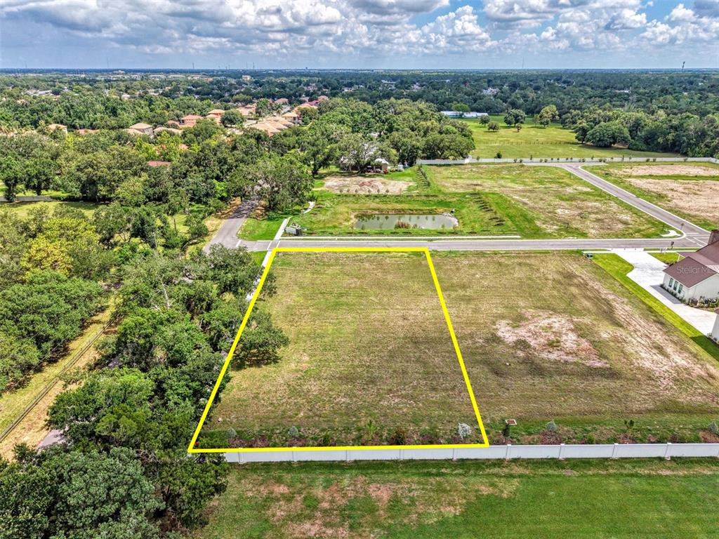 An aerial view shows a rectangular vacant lot outlined in yellow near a residential street — 6601 PALADIN CT, SARASOTA, FL