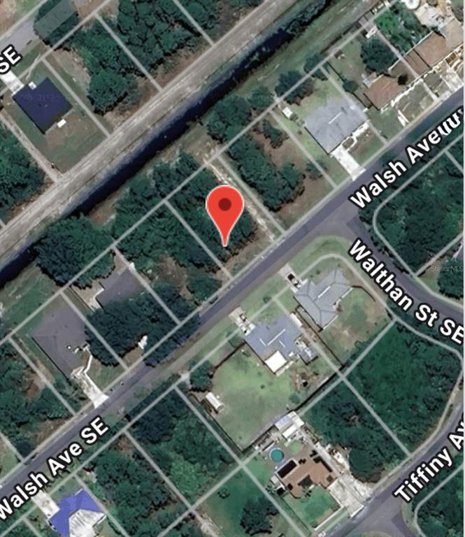 This is an aerial map view showing a vacant residential lot marked with a pin — 2024 WALSH AVENUE SE, PALM BAY, FL