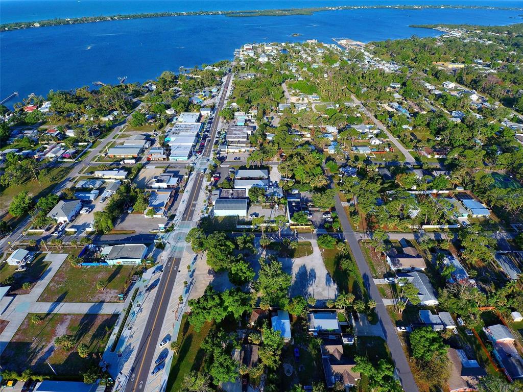 An aerial view shows a coastal town with a main road leading toward the water — 348 W DEARBORN STREET, ENGLEWOOD, FL