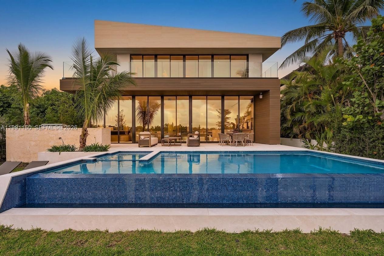 A modern two-story house features a swimming pool, glass sliding doors, and a wooden facade — 535 N Shore Dr, Miami Beach FL 33141, MIAMI BEACH, FL