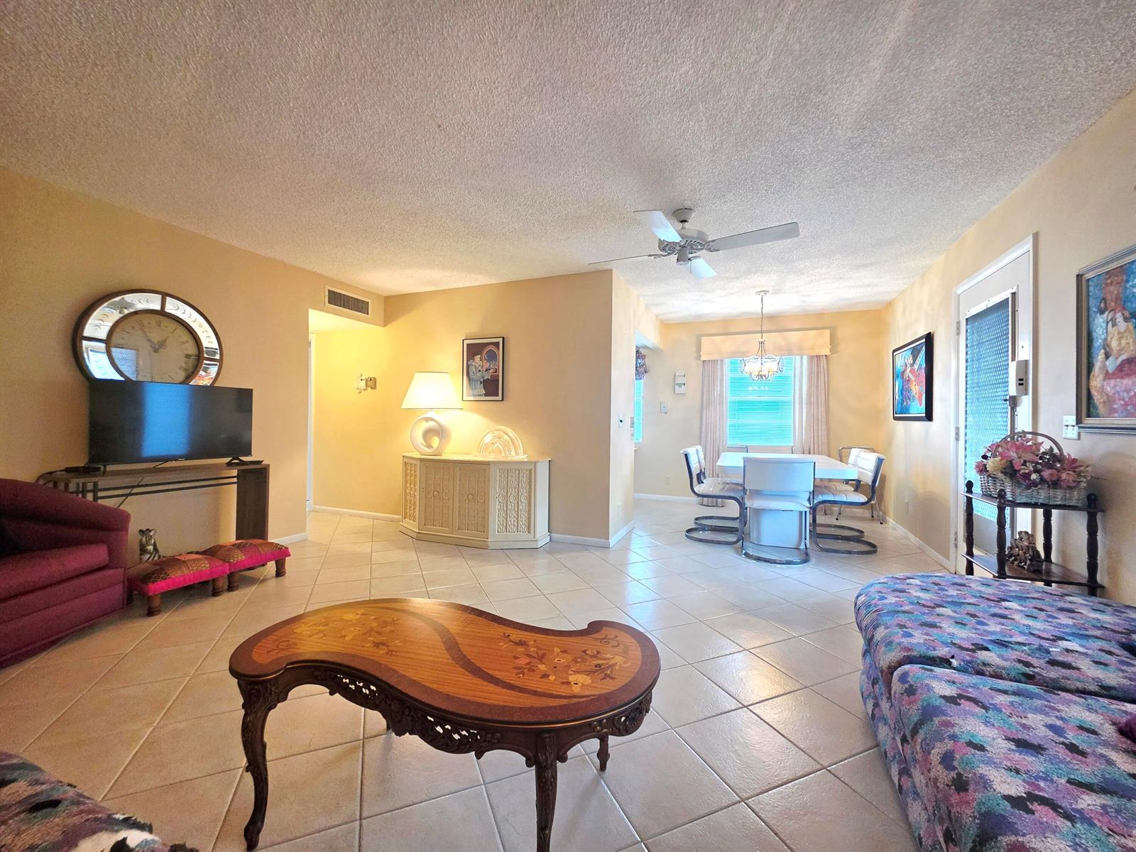A living and dining area features tile flooring, a ceiling fan, and traditional furniture — 719 Flanders Drive # O, Delray Beach FL 33484, DELRAY BEACH, FL