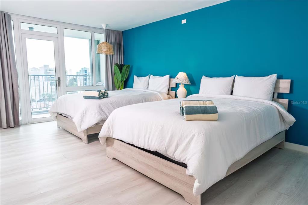 A bedroom features two beds with white bedding against a vibrant teal accent wall — 6165 AV. ISLA VERDE UNIT 659, CAROLINA, PR
