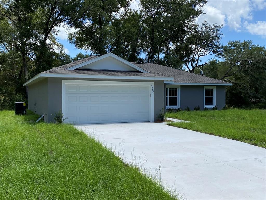 A single-story house with a gray exterior, a two-car garage, and a concrete driveway — 9065 N AKOLA WAY, CITRUS SPRINGS, FL