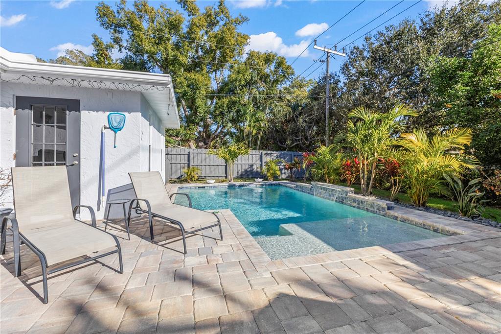 A backyard features a rectangular swimming pool with a tanning ledge and paver patio — 3122 N REGATTA CIRCLE, SARASOTA, FL