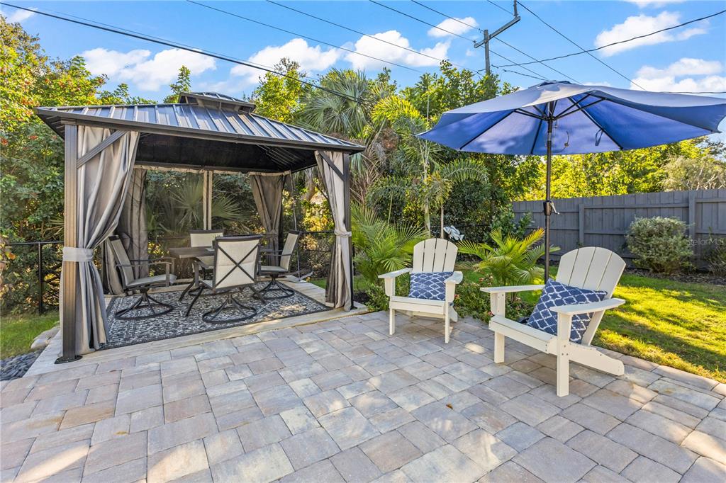 A backyard patio features a metal gazebo with dining furniture and two white chairs — 3122 N REGATTA CIRCLE, SARASOTA, FL