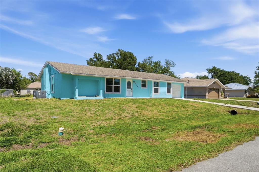 A single-story, light blue house with a shingled roof and a front-facing garage — 4530 CAZES AVENUE, NORTH PORT, FL