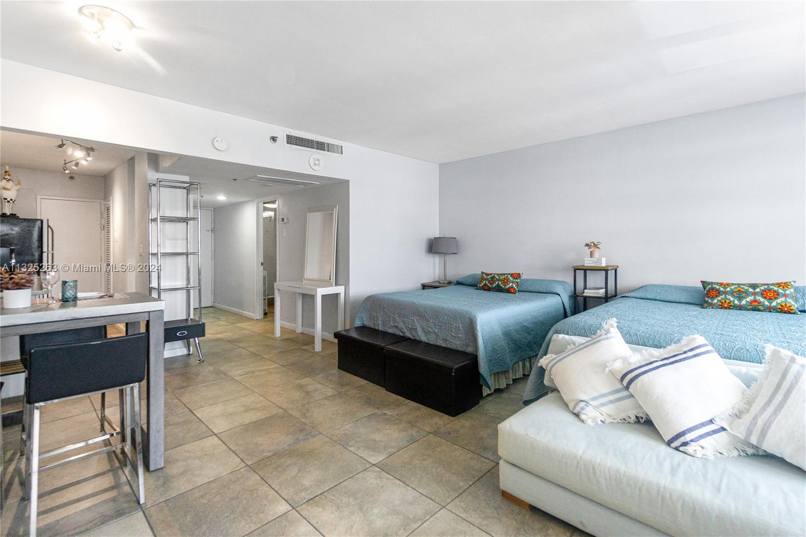 A studio apartment features two beds, a kitchen counter, and light-colored tile flooring — 100 Lincoln Rd # 320, Miami Beach FL 33139, MIAMI BEACH, FL