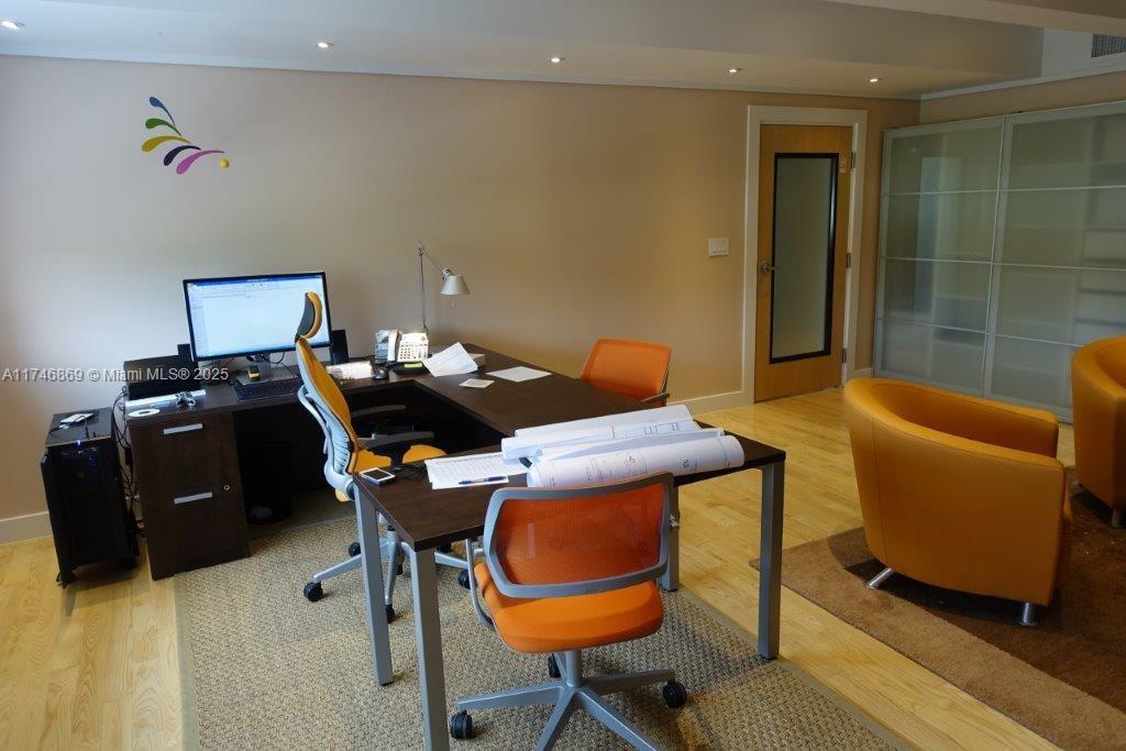A home office features a dark wood desk, orange chairs, and light wood flooring — 6130 NE 4th Ct, Miami FL 33137, MIAMI, FL