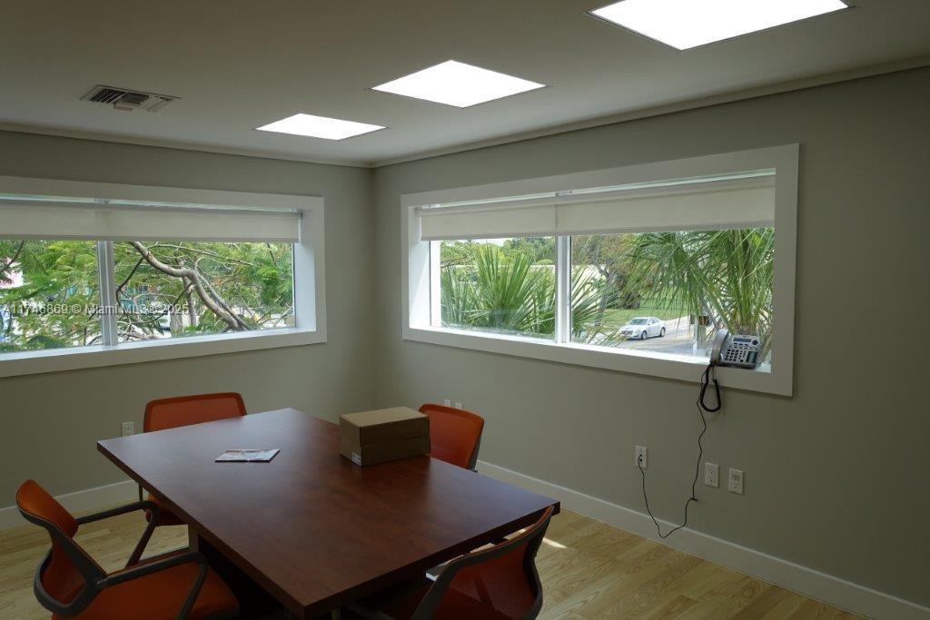 A conference room features a wooden table, orange chairs, large windows, and recessed ceiling lights — 6130 NE 4th Ct, Miami FL 33137, MIAMI, FL