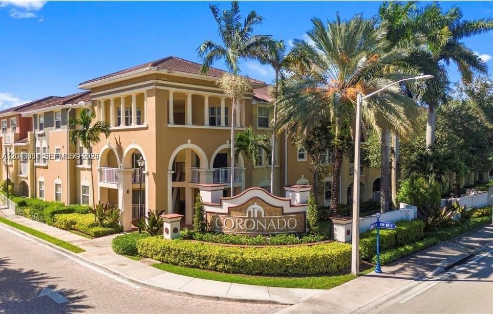 Exterior view of the multi-story Coronado apartment complex with palm trees and landscaping — 10885 NW 89th Ter # 203, Doral FL 33178, DORAL, FL