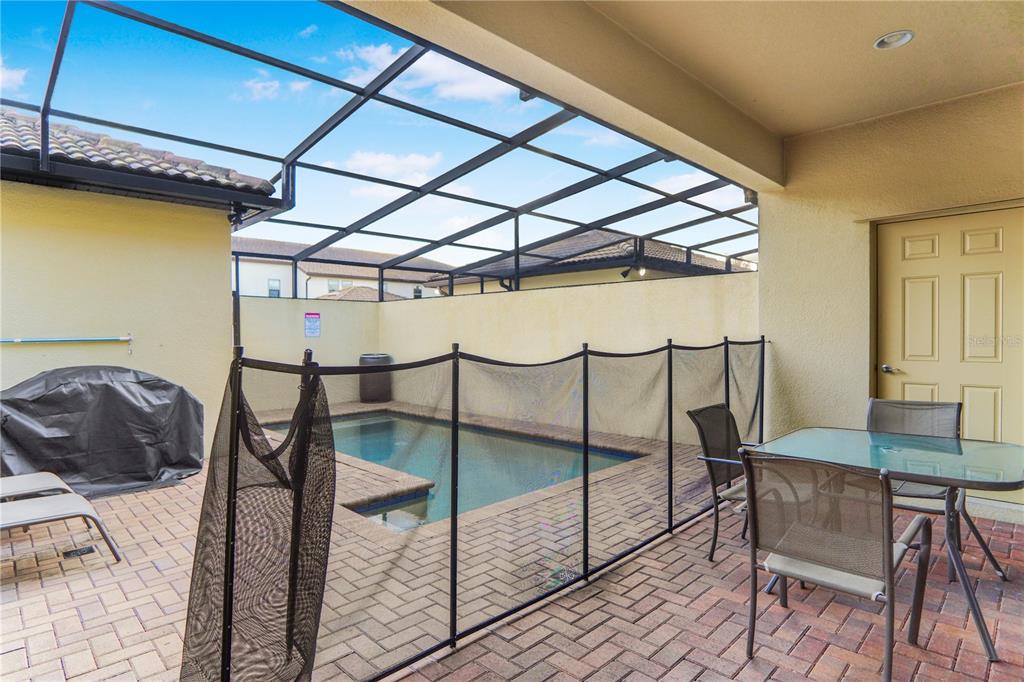 A screened-in patio features a small swimming pool, a safety fence, and outdoor furniture — 2022 MAJORCA DRIVE, KISSIMMEE, FL