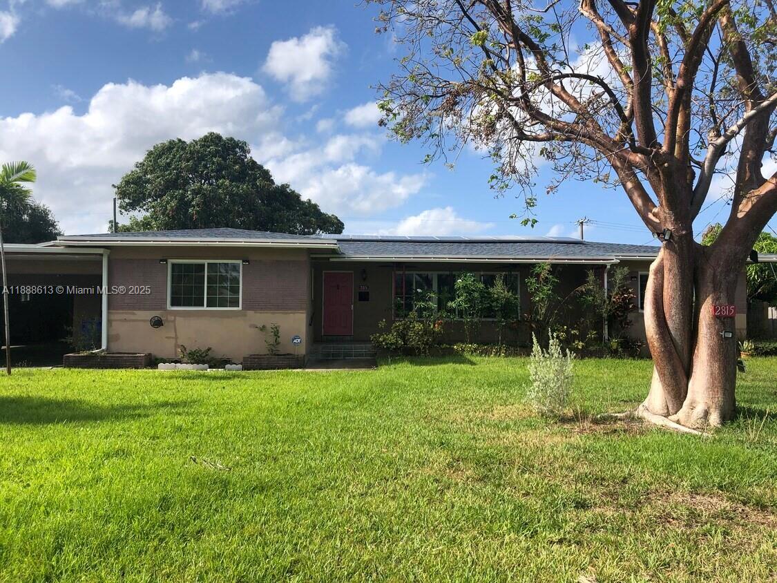 A single-story house with a pink front door and a large tree in the yard — 2815 Jackson St, Hollywood FL 33020, HOLLYWOOD, FL