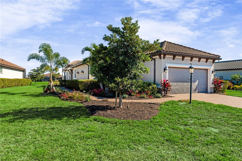 A single-story house with a two-car garage, a paved driveway, and landscaped front yard — 4743 MOTTA COURT, BRADENTON, FL