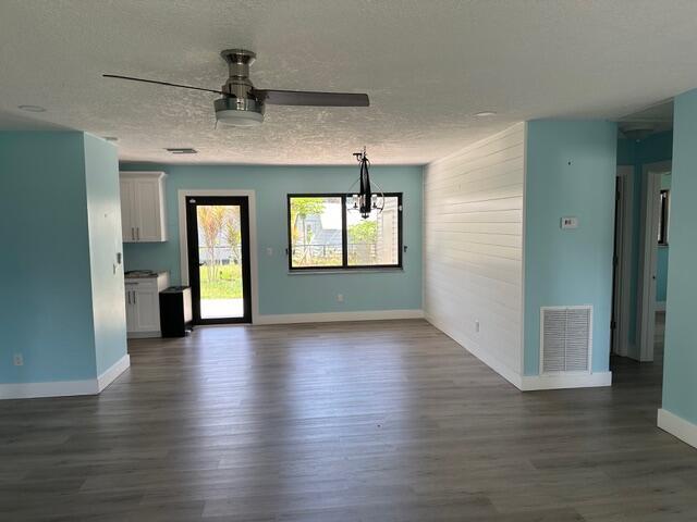 An open-concept room features light blue walls, wood-look flooring, a ceiling fan, and shiplap accents — 907 SE Lake Street, Stuart FL 34994, STUART, FL