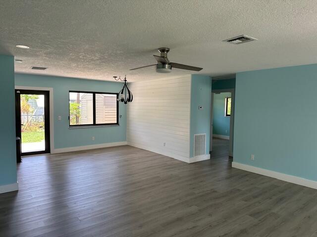 A living room with light blue walls, wood-look flooring, a shiplap accent wall, and ceiling fan — 907 SE Lake Street, Stuart FL 34994, STUART, FL
